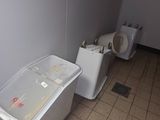 two toilets and a trash can in a bathroom