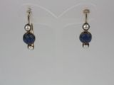 a pair of earrings with blue stones and pearls on them