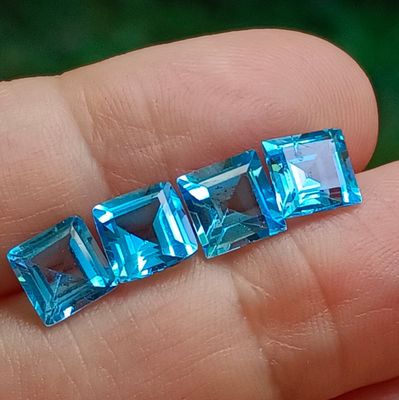 a person holding a piece of blue crystal in their hand