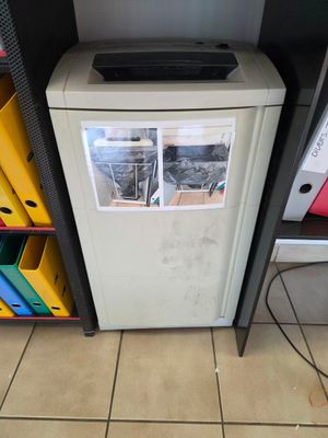 un petit réfrigérateur sur lequel sont posés de nombreux papiers