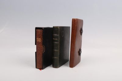 trois livres sont empilés sur une surface blanche