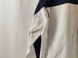 a white and blue jacket hanging on a white wall