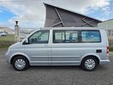a silver van parked in a parking lot with a tent on top of it