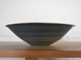 a black bowl sitting on top of a wooden table