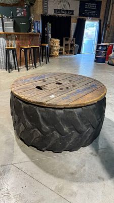 une table fabriquée à partir d'un pneu, posée à même le sol