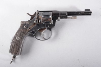 un vieux pistolet avec une poignée en bois sur une surface blanche