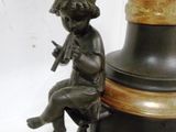 a statue of a boy sitting on top of a vase