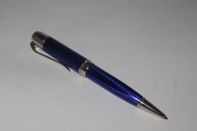 a blue pen that is laying on a white surface