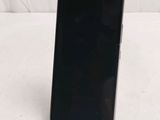 the back of a black cell phone sitting on top of a white surface