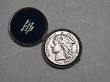 a silver coin in a black case on a table