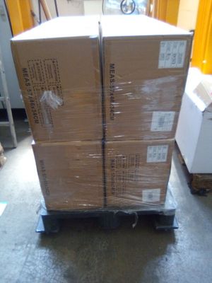 un carton contenant des boîtes posé sur un chariot dans un entrepôt