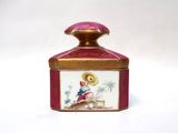 a small pink and gold box with a bird on it
