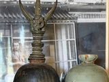 deux vases posés sur une table, avec un tableau en arrière-plan