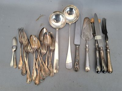 beaucoup d'argenterie sur une table avec des cuillères et des fourchettes