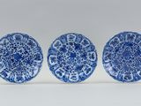 three blue and white plates with designs on them