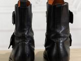 black leather ankle boots with buckles on a wooden table
