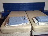 two twin beds in a room with a blue headboard