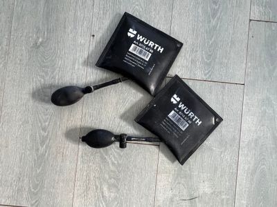 two bags of water sitting on the floor next to a pair of spoons