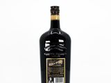 a bottle of black wine sitting on top of a white table