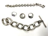 un ensemble composé d'un collier, d'un bracelet et d'une bague, posé sur une surface blanche