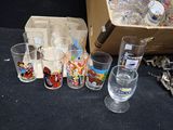 bottles and glasses are sitting on a table next to a box of assorted items