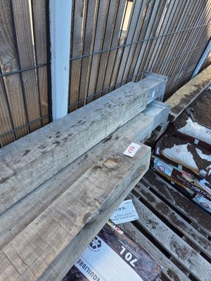 a pile of wood sitting on the ground next to a fence