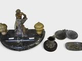 une statue représentant une femme assise sur une table, à côté d'autres objets