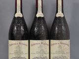 three bottles of red wine are lined up on a table