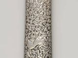 une cuillère en argent au manche sculpté, posée sur une table