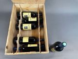 bottles of wine in a wooden box next to a bottle of wine