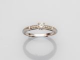 une bague en or blanc avec un diamant serti au centre