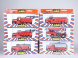 quatre camions rouges miniatures dans une boîte posée sur une surface blanche