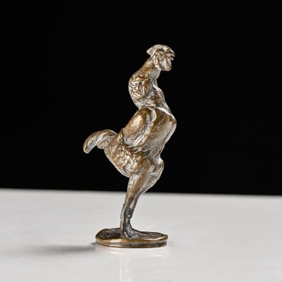 silver figurine of a man riding a horse on a white surface
