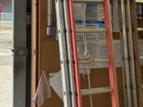 Plusieurs échelles sont appuyées contre un mur dans un garage.