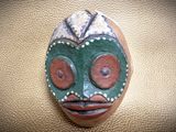 a stone with a mask on it sitting on a table