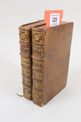 trois vieux livres empilés sur une surface blanche