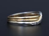 a close up of a gold and silver ring on a black surface