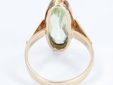 a close up of a ring with a green stone in it