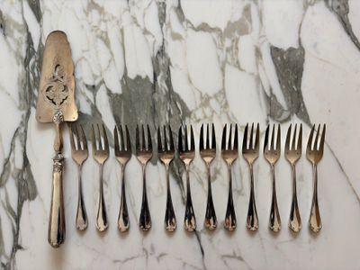 five forks and a knife on a marble table