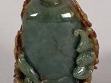 a picture of a green jade snuff bottle on a white surface