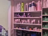 une salle de bains dont les étagères regorgent de produits capillaires