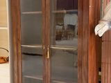 un grand meuble en bois avec des portes en verre dans une pièce