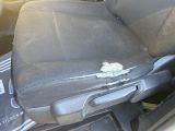 a dirty seat in the back of a car with a broken arm rest