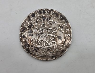 a close up of a silver coin with a ship on it