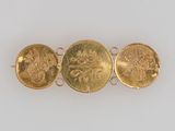 three gold coin bracelets, one with a lion and the other with a lion head