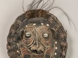 un gros plan d'un masque posé sur une surface blanche