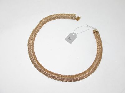 un gros plan d'un collier de couleur dorée muni d'une étiquette