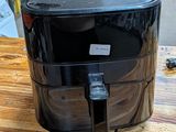 a black air fryer sitting on a wooden table