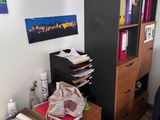 une photo d'une pièce encombrée avec un bureau et une bibliothèque