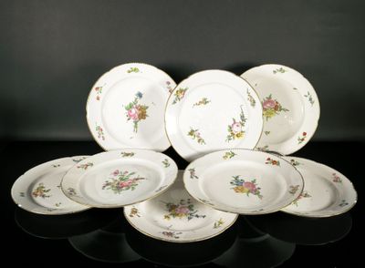 Plusieurs assiettes ornées de motifs floraux sont disposées sur un fond noir